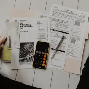 Unterlagen mit Rechner und Stift als Symbol für einen Businessplan für einen Hundesalon